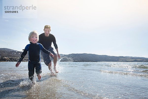 Vater und Sohn laufen am Strand  Loch Eishort  Isle of Skye  Hebrides  Schottland