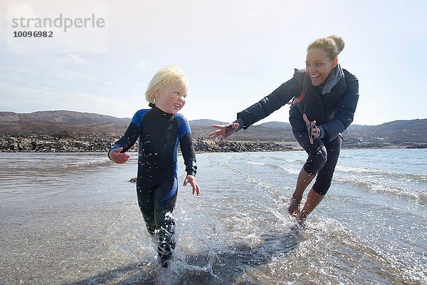 Mutter und Sohn laufen am Strand  Loch Eishort  Isle of Skye  Hebrides  Schottland