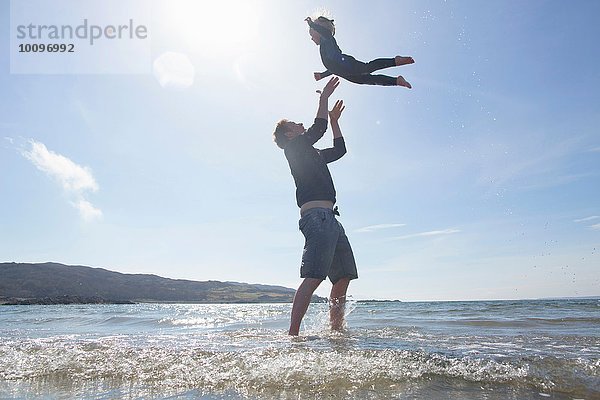 Vater wirft Sohn in die Luft am Strand  Loch Eishort  Isle of Skye  Hebrides  Schottland