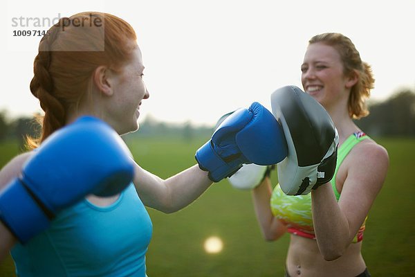 Zwei Frauen beim Training mit Boxhandschuhen im Park