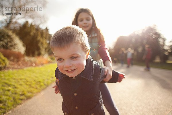 Junge und Schwester spielen im Park