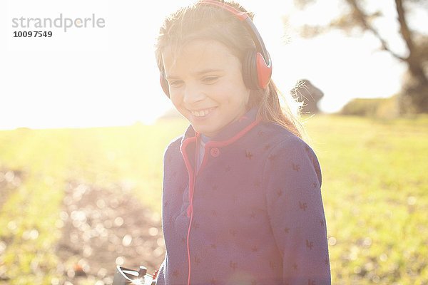 Lächelndes Mädchen mit Kopfhörer Metalldetektion im Feld