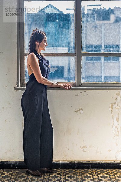 Mittlere erwachsene Frau mit Blick aus dem Fenster