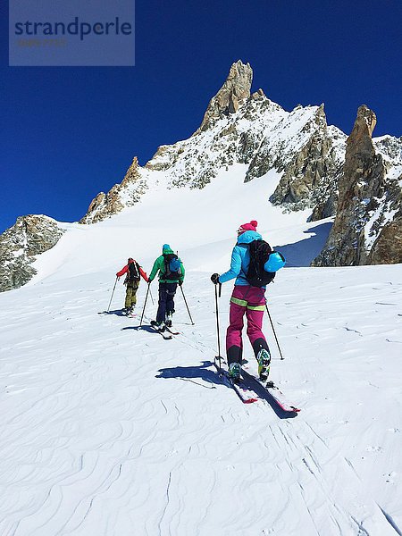 Rückansicht von drei erwachsenen Skifahrern  die das Mont-Blanc-Massiv erklimmen  Graian Alps  Frankreich