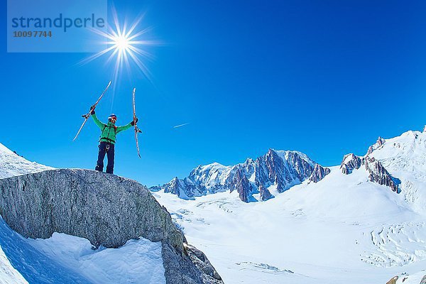 Älterer Skifahrer  der die Skier auf dem Mont Blanc-Massiv  Graian Alps  Frankreich  hochhält.