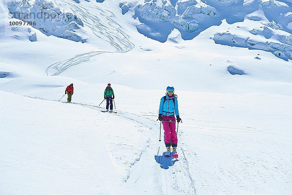 Reihe von drei erwachsenen Skifahrern  die das Mont-Blanc-Massiv hinunterfahren  Graian Alps  Frankreich