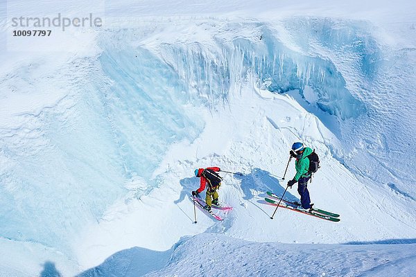 Zwei männliche Skifahrer  die die Schlucht des Mont-Blanc-Massivs hinunterfahren  Graian Alps  Frankreich