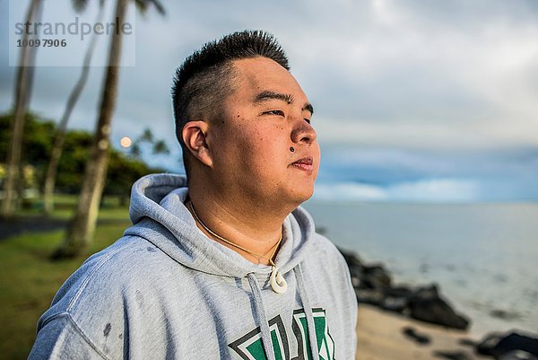 Junger Mann bei Sonnenaufgang vom Kaaawa Strand  Oahu  Hawaii  USA