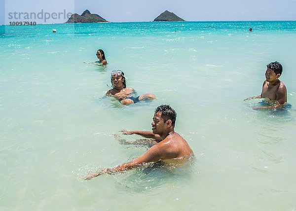 Vier junge erwachsene Freunde spielen im Meer am Lanikai Beach  Oahu  Hawaii  USA