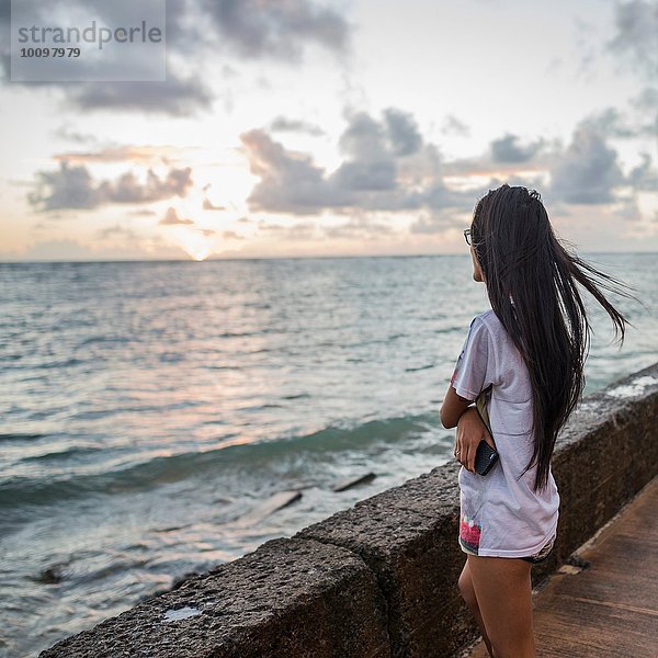 Junge Frau beim Sonnenaufgang  Kaaawa Strand  Oahu  Hawaii  USA