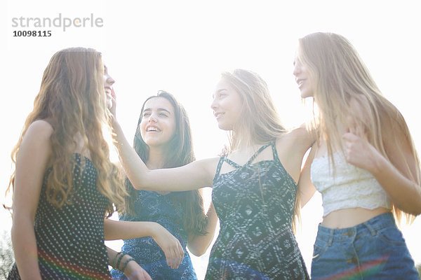 Vier Teenager-Mädchen beim Chatten im Park