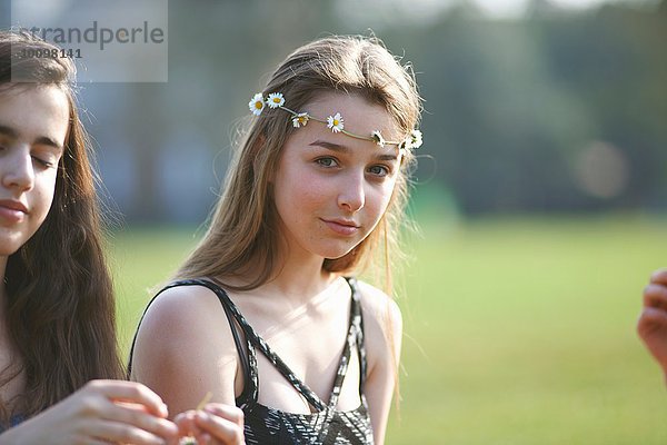 Porträt eines Teenagermädchens mit Gänseblümchen-Kopfschmuck im Park