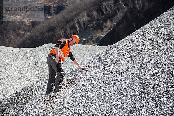 Steinbrucharbeiter beim Messen auf Kieshügel im Steinbruch