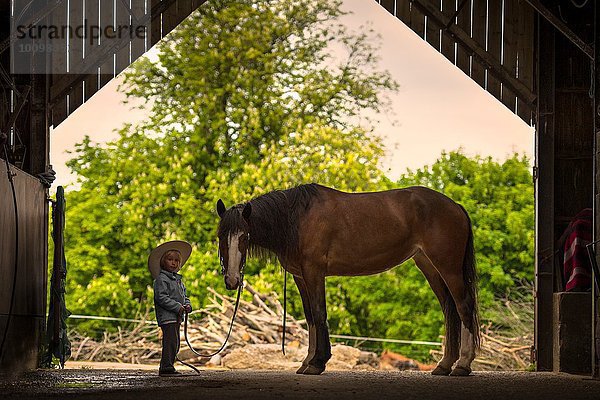 Junge stehend mit Pferd