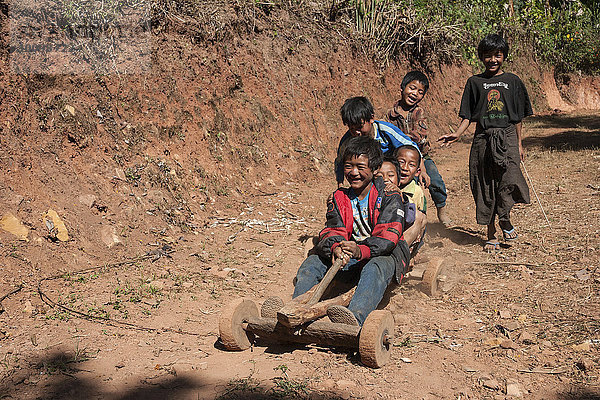Kinder vom Volkstamm der Palaung fahren mit einem selbstgebauten Fahrzeug  bei Kalaw  Shan-Staat  Myanmar  Asien