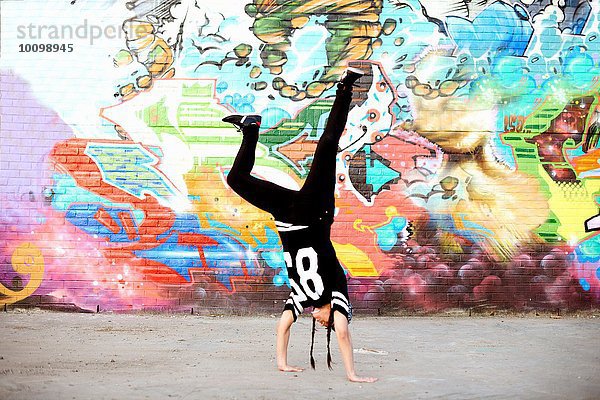 Junge Frauen im Handstand Breakdance Freeze gegen Graffiti