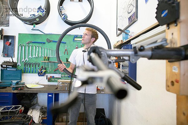 Mittlerer Erwachsener Mann in der Werkstatt mit Fahrradreifen