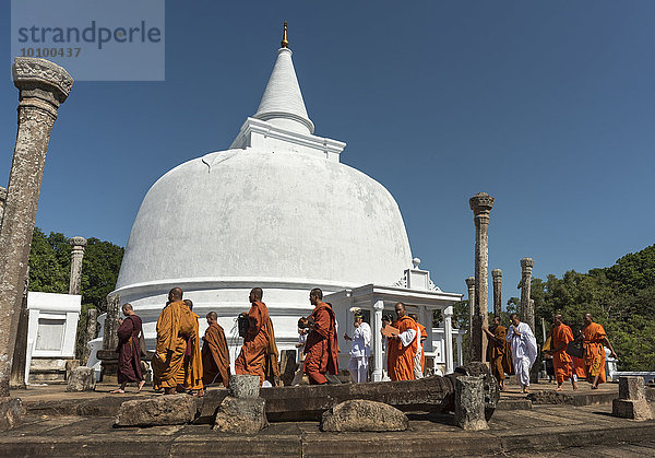 Buddhistische Mönche laufen um die Lankaramaya Dagoba oder Lankarama Stupa herum  Anuradhapura  Sri Lanka  Asien