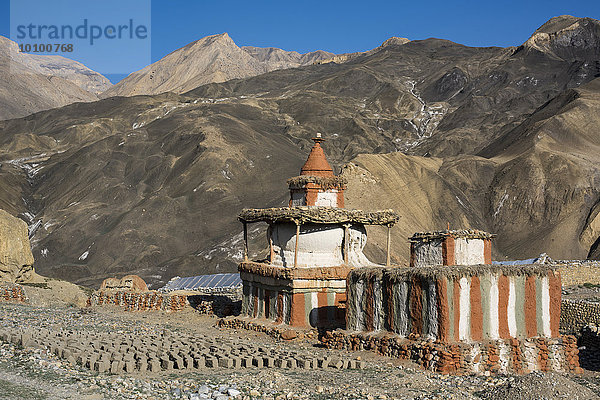 Buddhistische Stupas  Tschörten vor Berglandschaft  Gebetsschrein oder Reliquienschrein  am Boden liegen getrocknete Lehmziegel auch Adobe genannt  Tangge  ehemaliges Königreich Mustang  Nepal  Asien