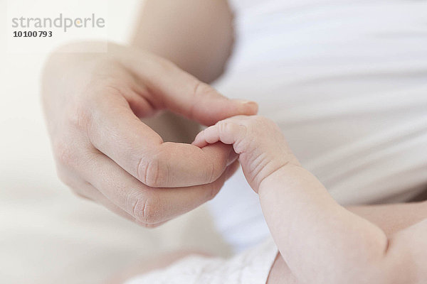 Mutter hält Hand des weiblichen Babies