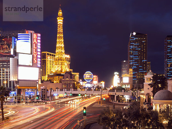 Blick entlang des Strip in Las Vegas bei Nacht  mit dem beleuchteten Pariser Las Vegas Hotel und Casino im Hintergrund.