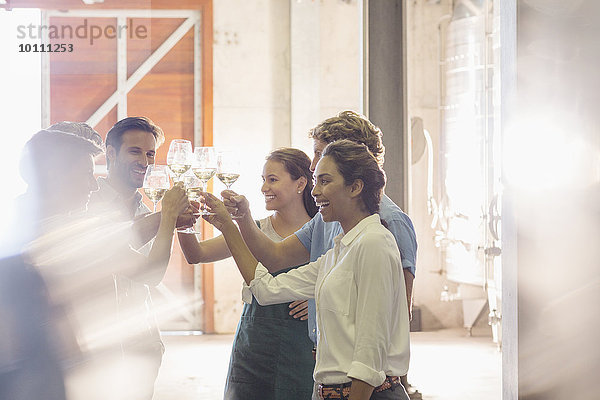 Freunde toasten Weingläser im Weingut