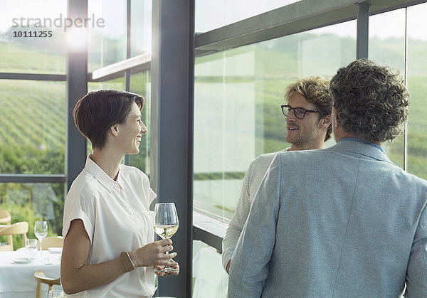 Freunde trinken Weißwein im Verkostungsraum des Weingutes