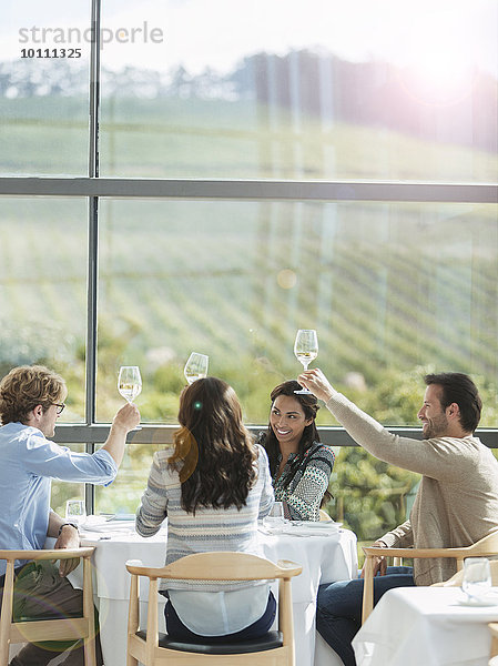 Freunde toasten Weingläser im Speisesaal des Weingutes