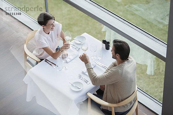 Paar Toastweingläser am Restauranttisch am Fenster