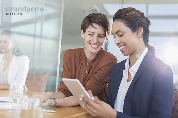 Lächelnde Geschäftsfrauen mit digitalem Tablett im Büro