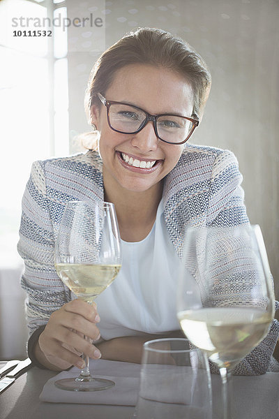 Portrait selbstbewusste Frau mit Brille trinkt Weißwein