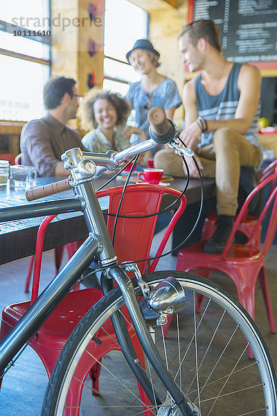 Freunde  die im Cafe hinter dem Fahrrad rumhängen