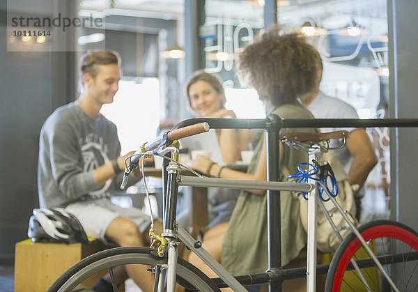 Freunde  die im Cafe hinter dem Fahrrad rumhängen