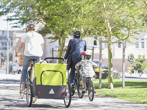 Familien auf dem Fahrrad im sonnigen Stadtpark