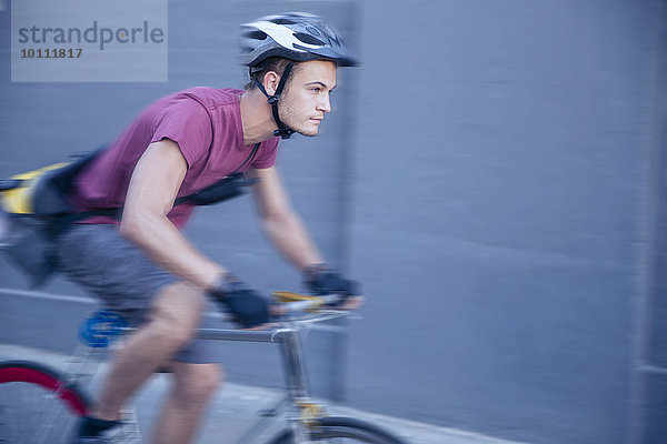 Fokussierter Fahrradkurier mit Helm unterwegs