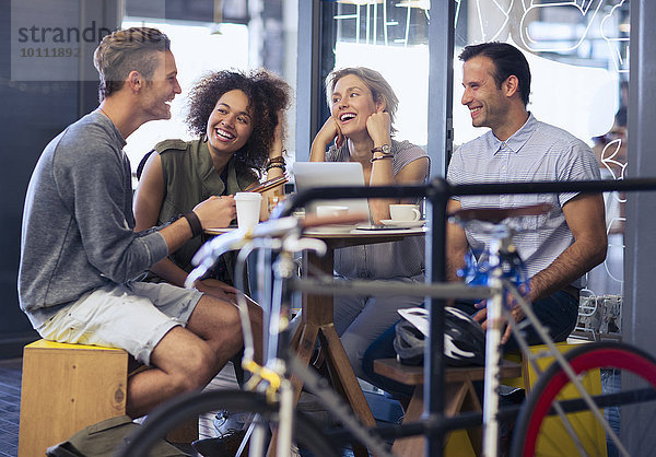 Freunde  die im Café hinter dem Fahrrad rumhängen