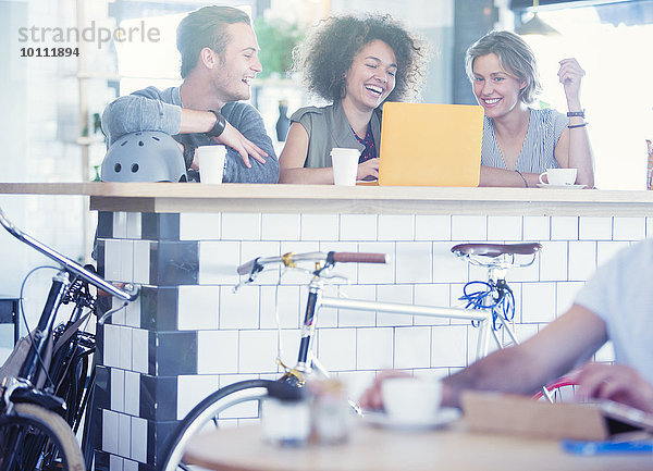 Freunde teilen Laptop an der Cafe Bar