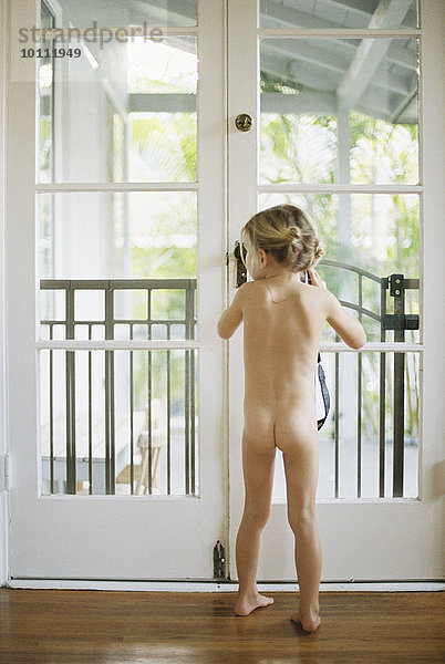 stehend Glas Tür Rückansicht Ansicht jung nackt Mädchen