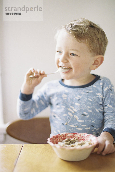 sitzend Junge - Person jung Schüssel Schüsseln Schale Schalen Schälchen essen essend isst Tisch Frühstück