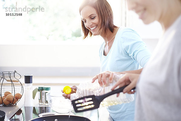 Lächelnde Frauen beim Kochen in der Küche