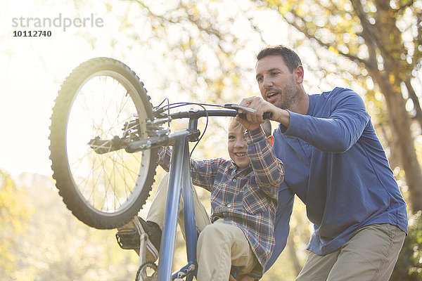 unterrichten Menschlicher Vater Sohn Fahrrad Rad nur auf dem Hinterrad fahren