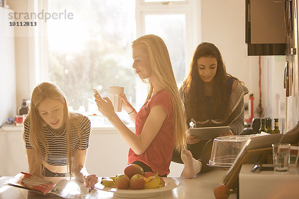 benutzen Jugendlicher Kurznachricht Küche Zeitschrift Tablet PC Mädchen vorlesen