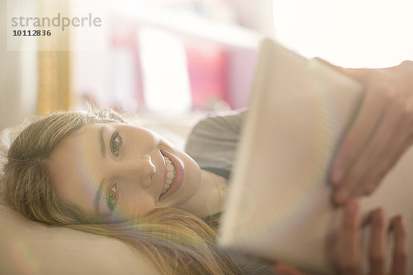 benutzen Portrait Jugendlicher lächeln Bett Tablet PC Mädchen