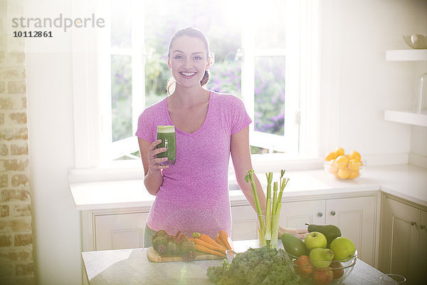 Portrait Frau lächeln Küche grün trinken smoothie