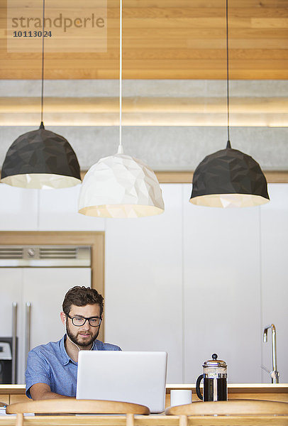 benutzen Mann Notebook Küche unterhalb Beleuchtung Licht hängen