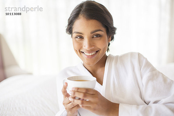 Portrait Frau lächeln Bademantel trinken Tee
