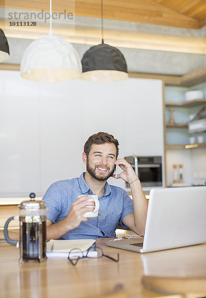 Handy Mann sprechen Notebook lächeln trinken Kaffee