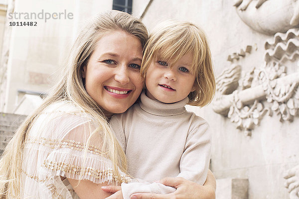 Mutter umarmt junge Tochter im Freien  Portrait