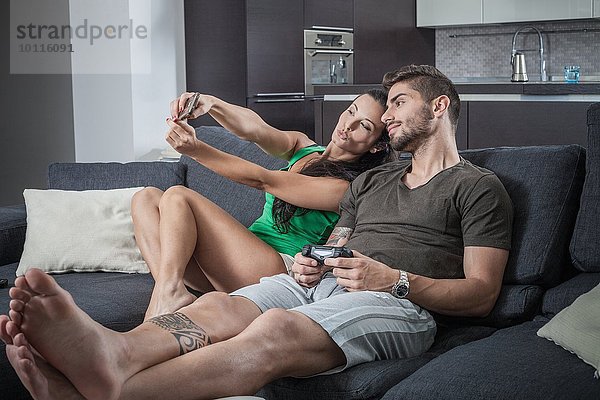 Junges Paar auf dem Sofa mit Smartphone Selfie