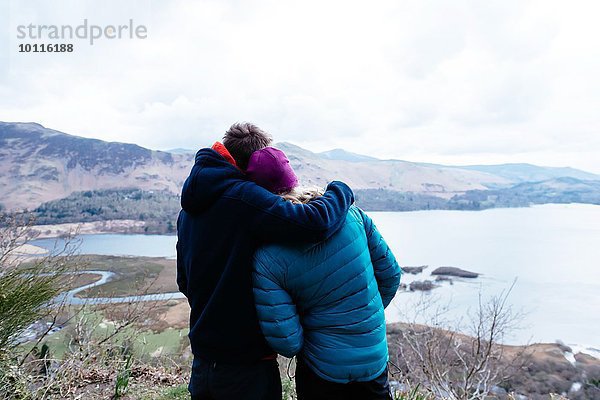 Junges Paar beim Wandern  Ausblick  Rückansicht  Derwent Water  Keswick  Lake District  Cumbria  Großbritannien